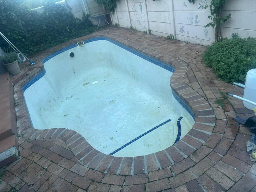 Old pool with a rough, discoloured finish before resurfacing