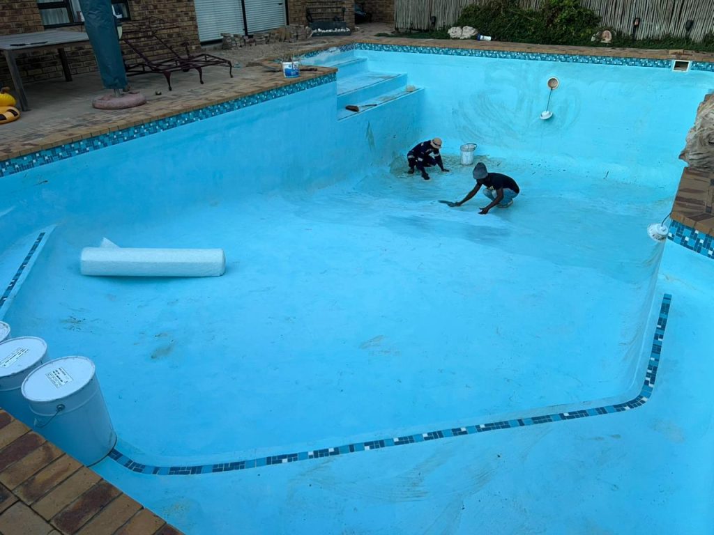 Pool resurfacing in progress on a drained concrete pool