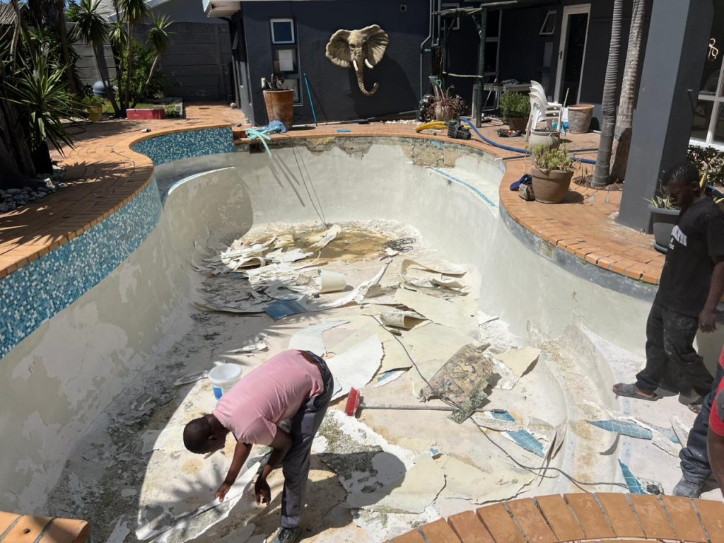Drained pool showing the damaged surface before repairs
