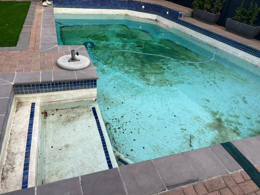 Worn, stained pool surface before renovation