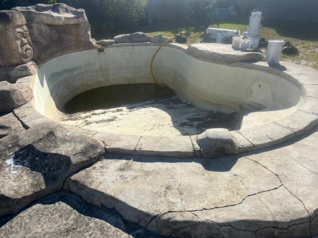 Worn, stained pool surface before renovation