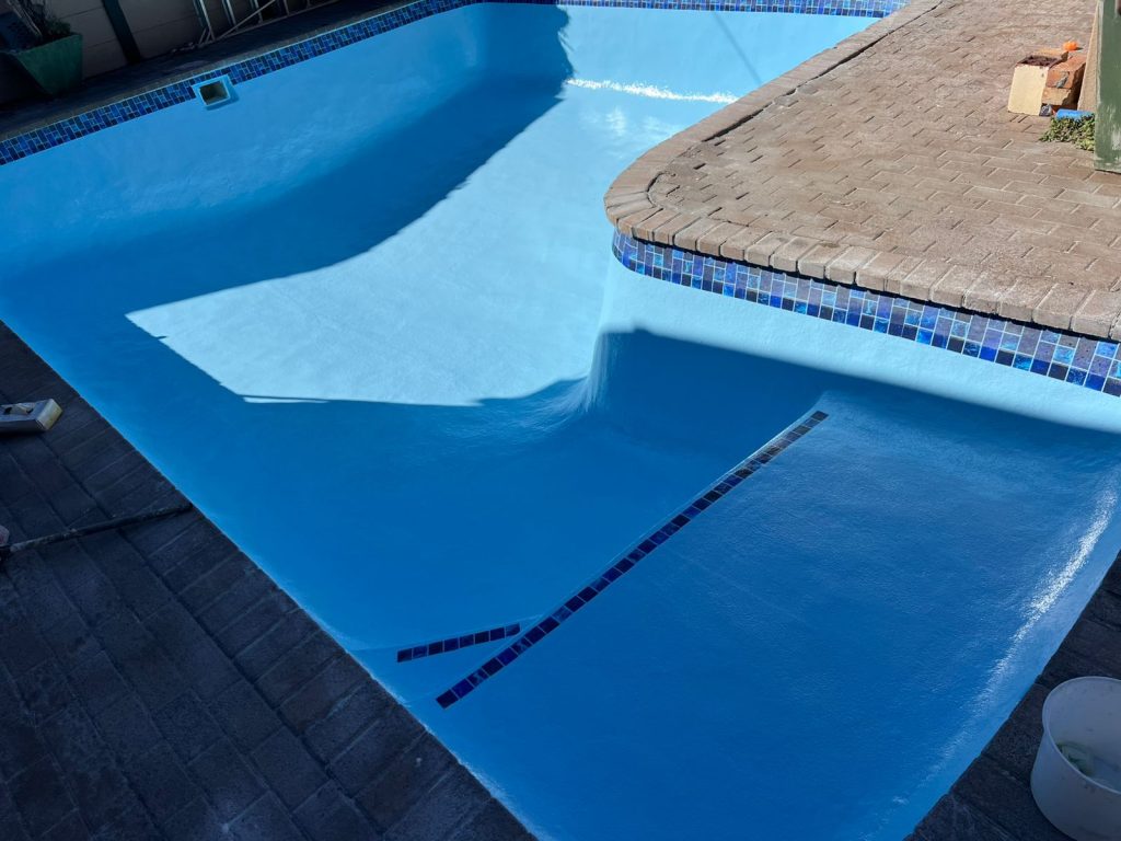 Finished pool renovation with a smooth blue interior