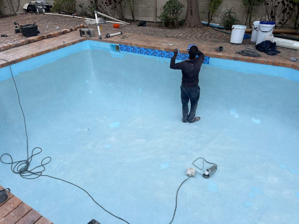 Pool resurfacing in progress on a drained concrete pool
