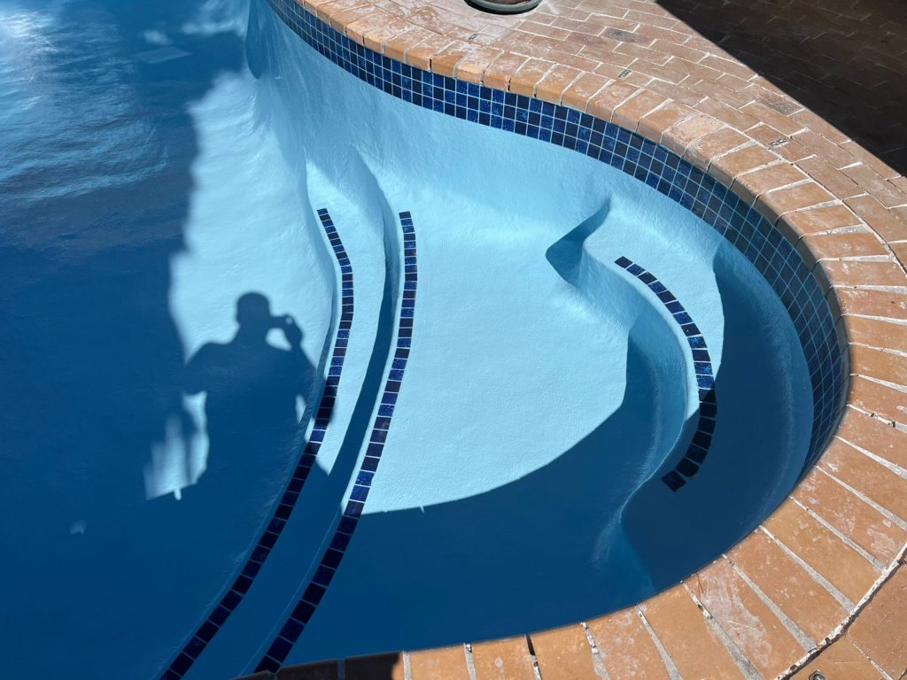 Finished pool renovation with a smooth blue interior