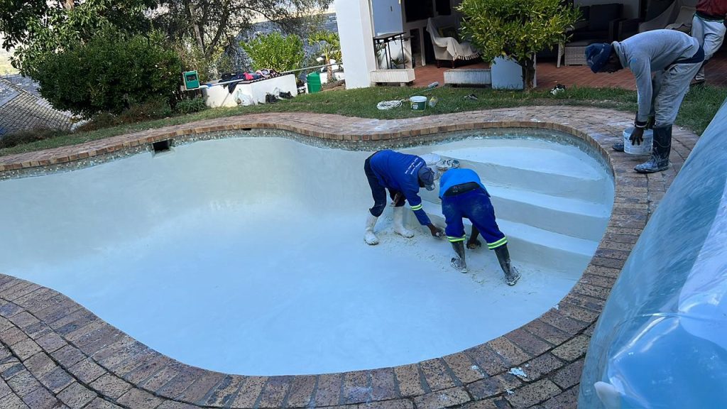 Fibreglass pool relining being applied by hand