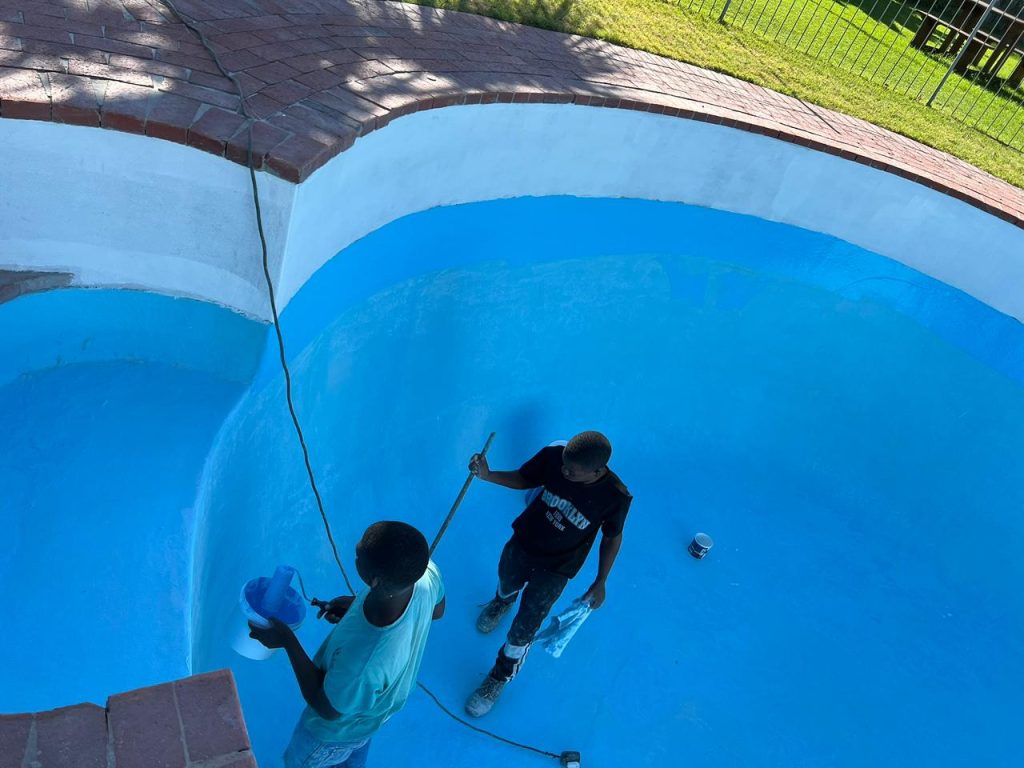 Fibreglass pool relining being applied by hand