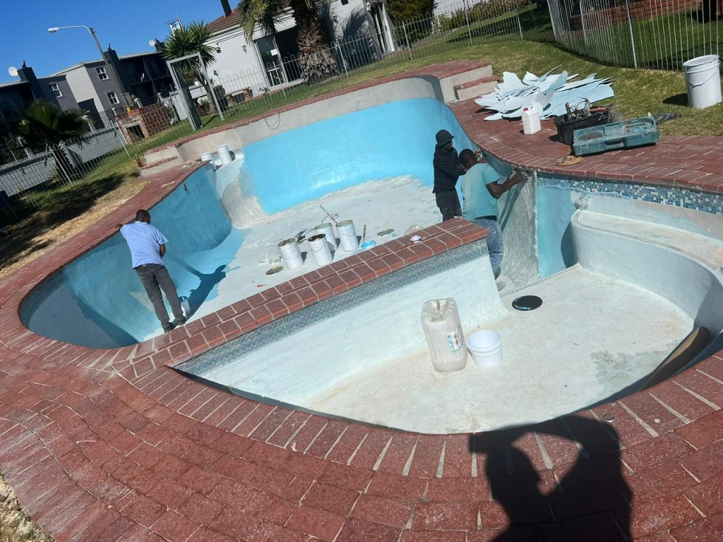 Pool resurfacing in progress on a drained concrete pool