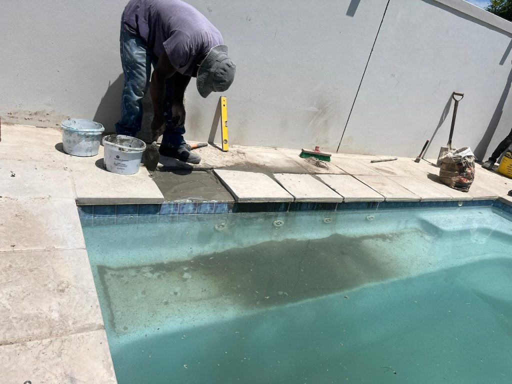 Drained pool showing the damaged surface before repairs