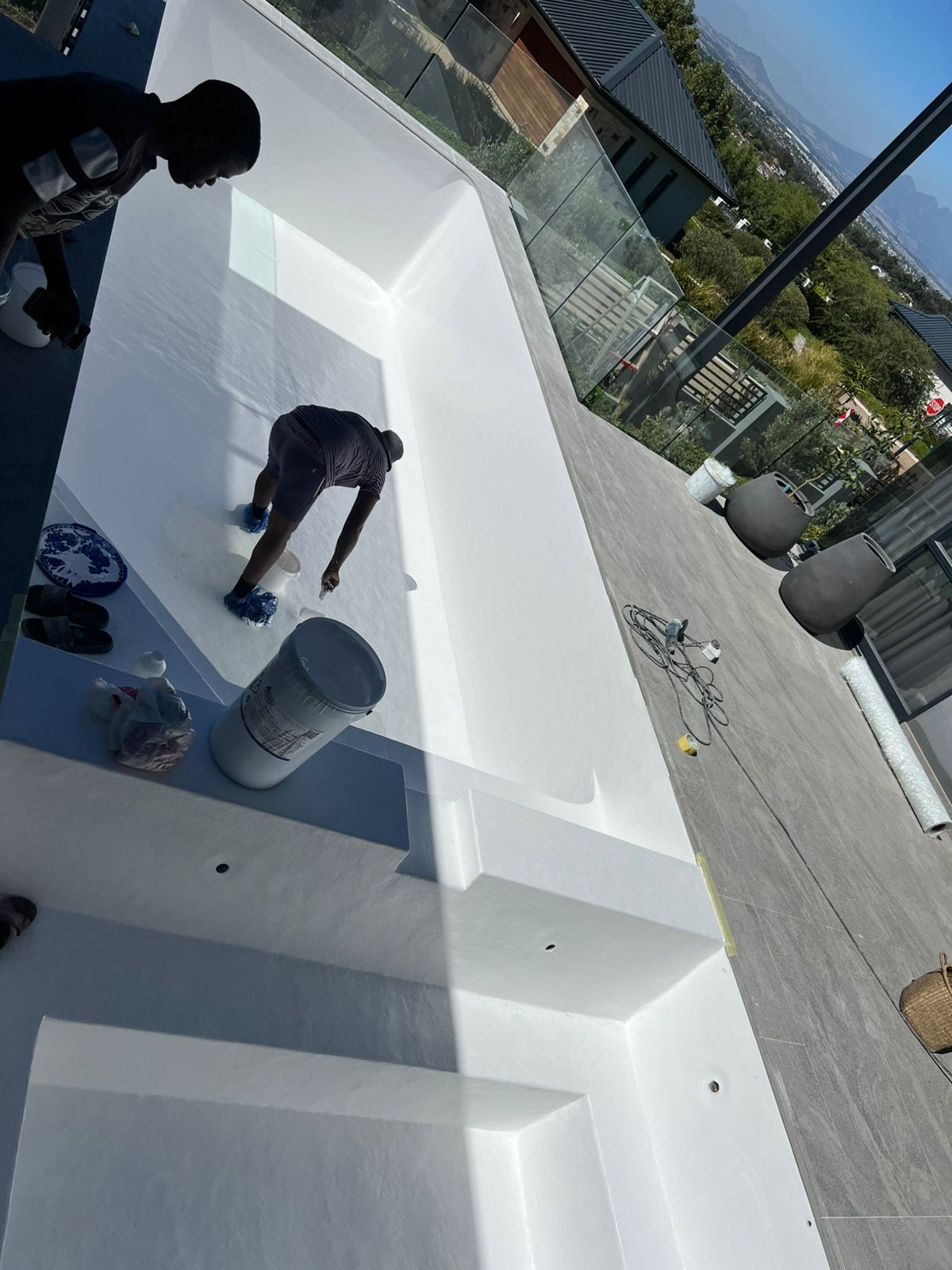Aquatic Pools installer applying a white fibreglass finish inside an empty pool